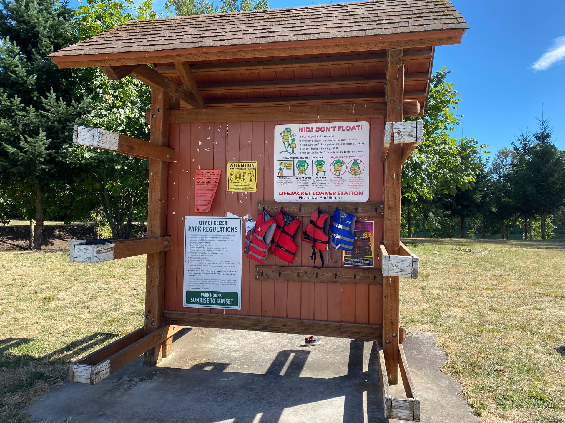Life jacket loaner station at Keizer Rapids Park with red and blue jackets on hooks.